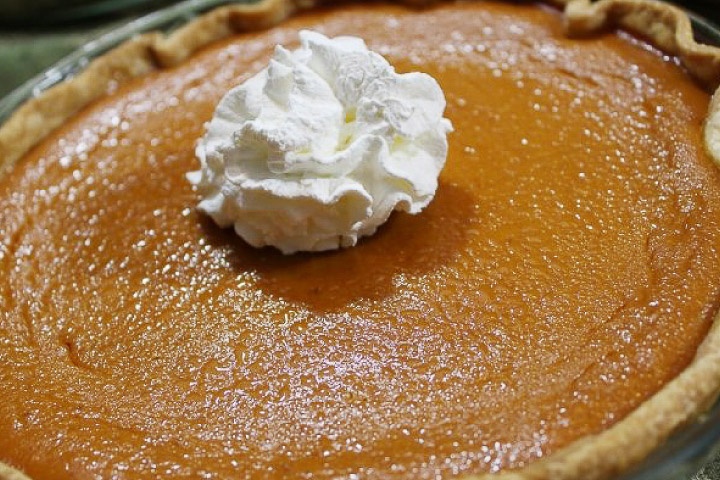 Baked pumpkin pie garnished with whipped cream