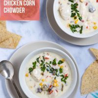 Two bowls of Southwest Chicken Corn Chowder on saucers with cilantro and tortilla chips to the side with text Easy Cheesy Chicken Corn Chowder.