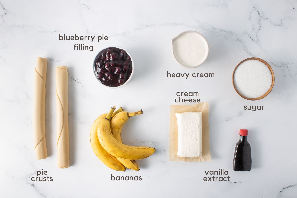 Ingredients for Banana Blueberry Pie with Cream Cheese: 2 refrigerated pie crusts, blueberry pie filling, bananas, heavy cream, cream cheese, vanilla extract, and sugar.