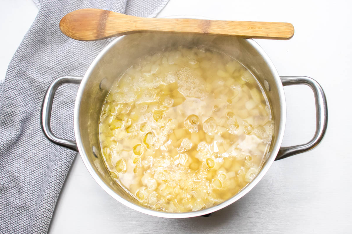 Potato soup after adding chicken broth and hash browns to the sautéed onions.