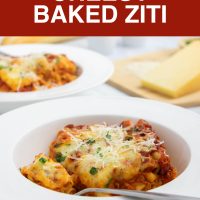 Bowl of cheesy meatless baked ziti garnished with fresh parsley and grated Parmesan cheese.