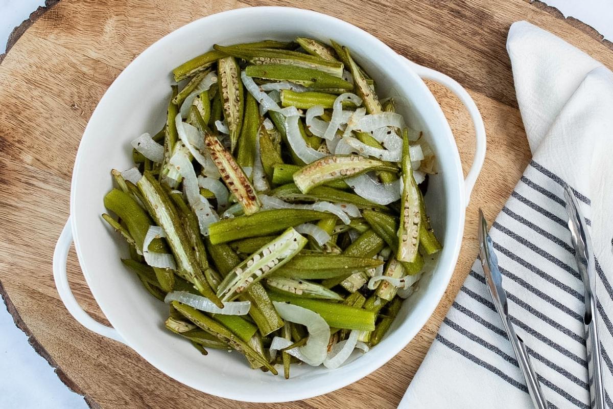 roasted sliced okra and onions in a white bowl.