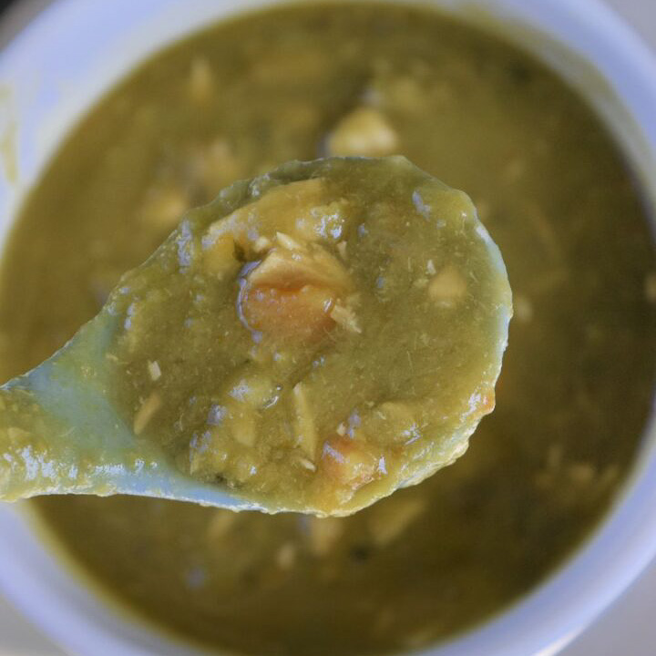 Ladle with a serving of slow cooker split pea soup.